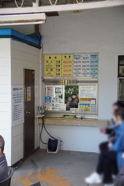 券売窓口とその上に掲示された料金表の写真