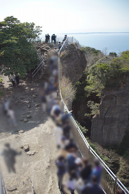 柵に沿って30人ほどの人々が並んでいる写真