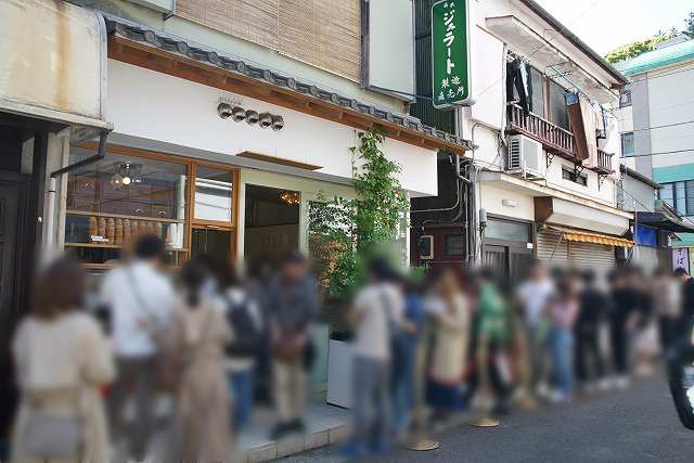 看板に「ジェラート」と書かれた店の前に行列ができている写真