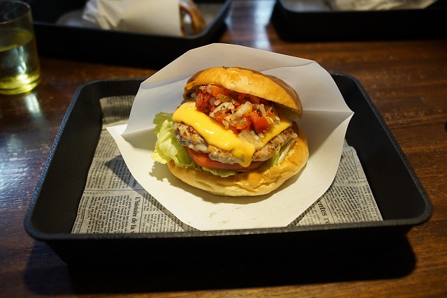 Foto de la hamburguesa envuelta en papel y en una bandeja