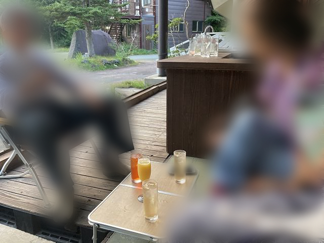 テーブルに置かれたドリンク4個とそれを囲む人たちの写真