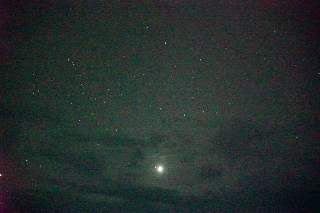 Foto del cielo estrellado. Se ven algunas nubes en la mitad inferior del cielo