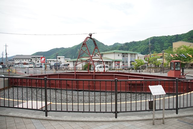 転車台の写真。大きなえんじ色の細長い金属の台が地面に弧状の跡を描いています