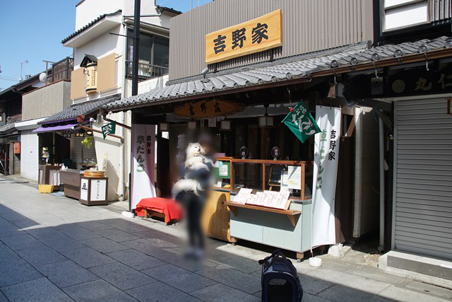 吉野家の前で白イヌを抱く人の写真