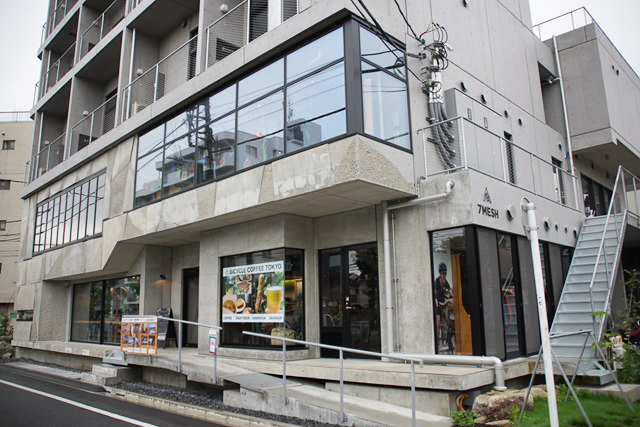 ビルの1階・2階が写った写真。お店の名前とともに料理や飲み物の写真が窓に貼られています