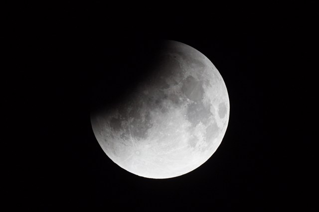 左上が丸く3分の1ほど欠けた月の写真